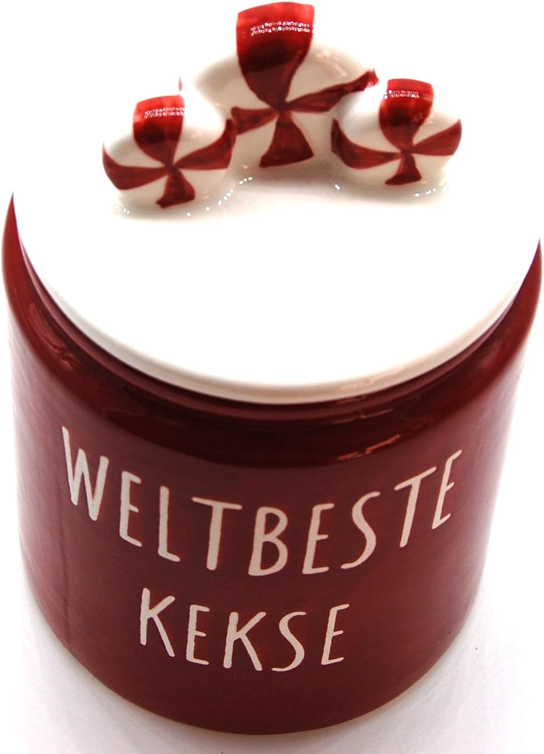 Nahaufnahme Exner Keksdose "Weltbeste Kekse" mit Candy-Deckel von oben Close-up Ansicht der geschlossenen handbemalten Exner Keramik Keksdose in Rot. Der weiße Deckel ist mit drei rot-weiß gestreiften Candys dekoriert. Der weiße Spruch "WELTBESTE KEKSE" in Großbuchstaben ist auf der Vorderseite gut sichtbar.
