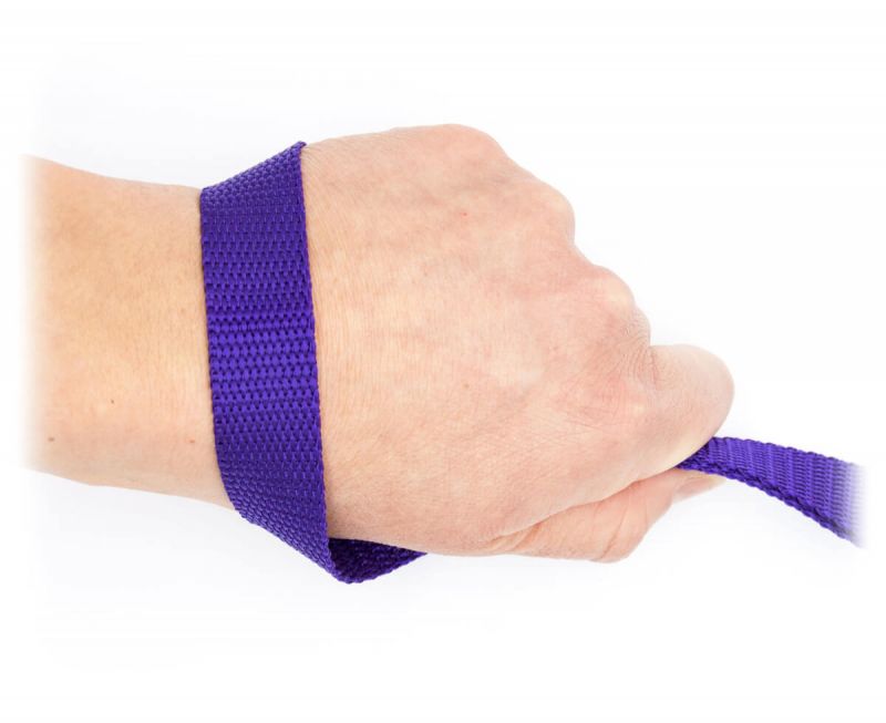 Handschlaufe einer lila Leine aus leichten Gurtband um ein Handgelenk gelegt. Die Handschlaufe wird vorne von Daumen und Zeigefinger zusammengedrückt