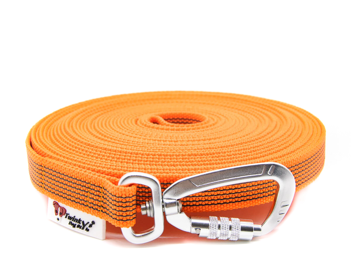 Einzelaufnahme Orange Schleppleine von Twinkys Dog Style gummiert 20 mm mit Sicherheitskarabiner Orange gummierte Schleppleine mit Sicherheitskarabiner liegt aufgerollt auf weißem Hintergrund