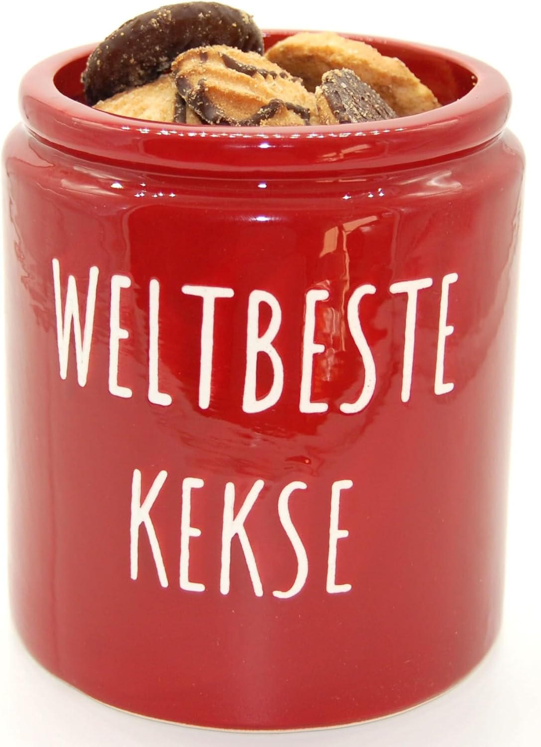 Rote Keramik Keksdose gefüllt mit verschiedenen Plätzchen. Der Deckel fehlt, um den Inhalt zu zeigen. Die Aufschrift "WELTBESTE KEKSE" ist in Weiß auf der Dose.