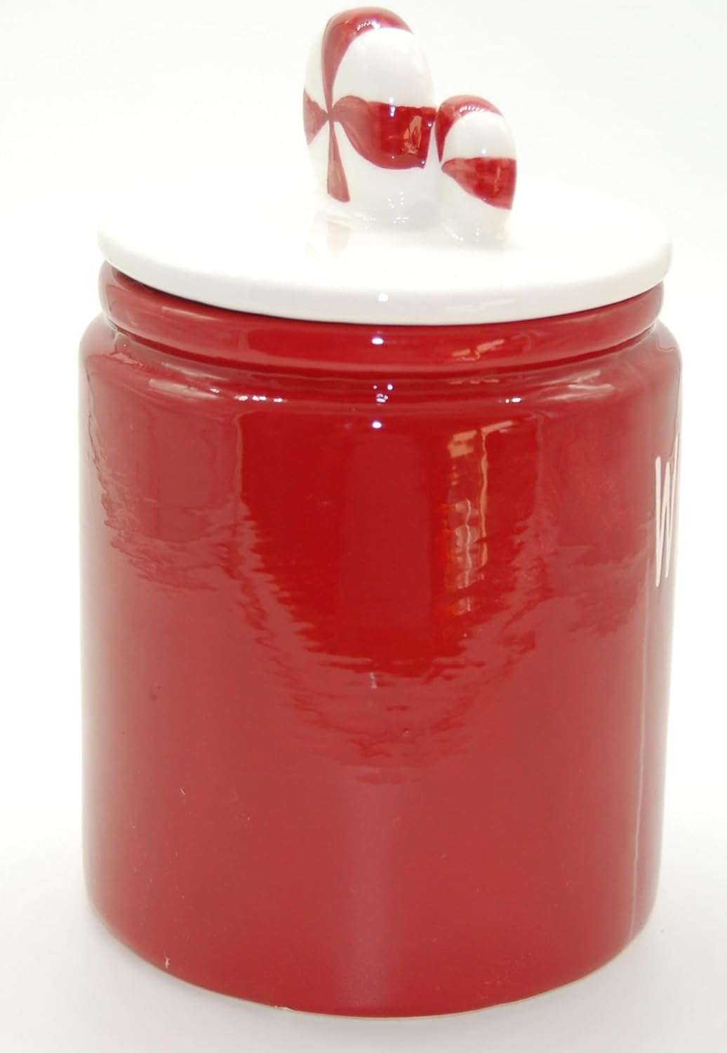 Seitenansicht der roten, glänzenden Keramik Keksdose mit weißem Deckel. Der Candy-Schmuck auf dem Deckel ist im Fokus. Die Seite der Dose ist unbeschriftet.